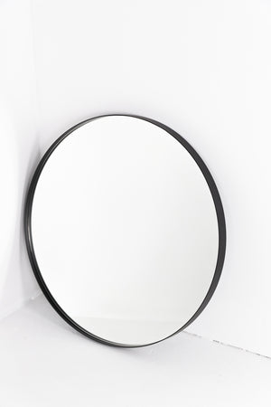 Round mirror set back in black frame