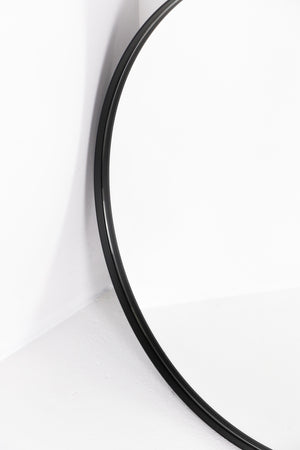 Round mirror set back in black frame