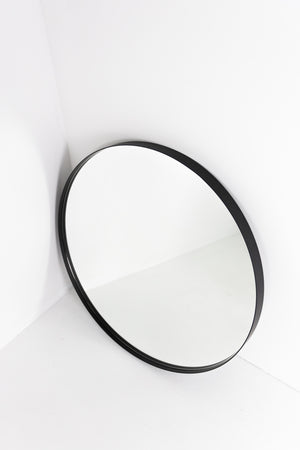 Round mirror set back in black frame
