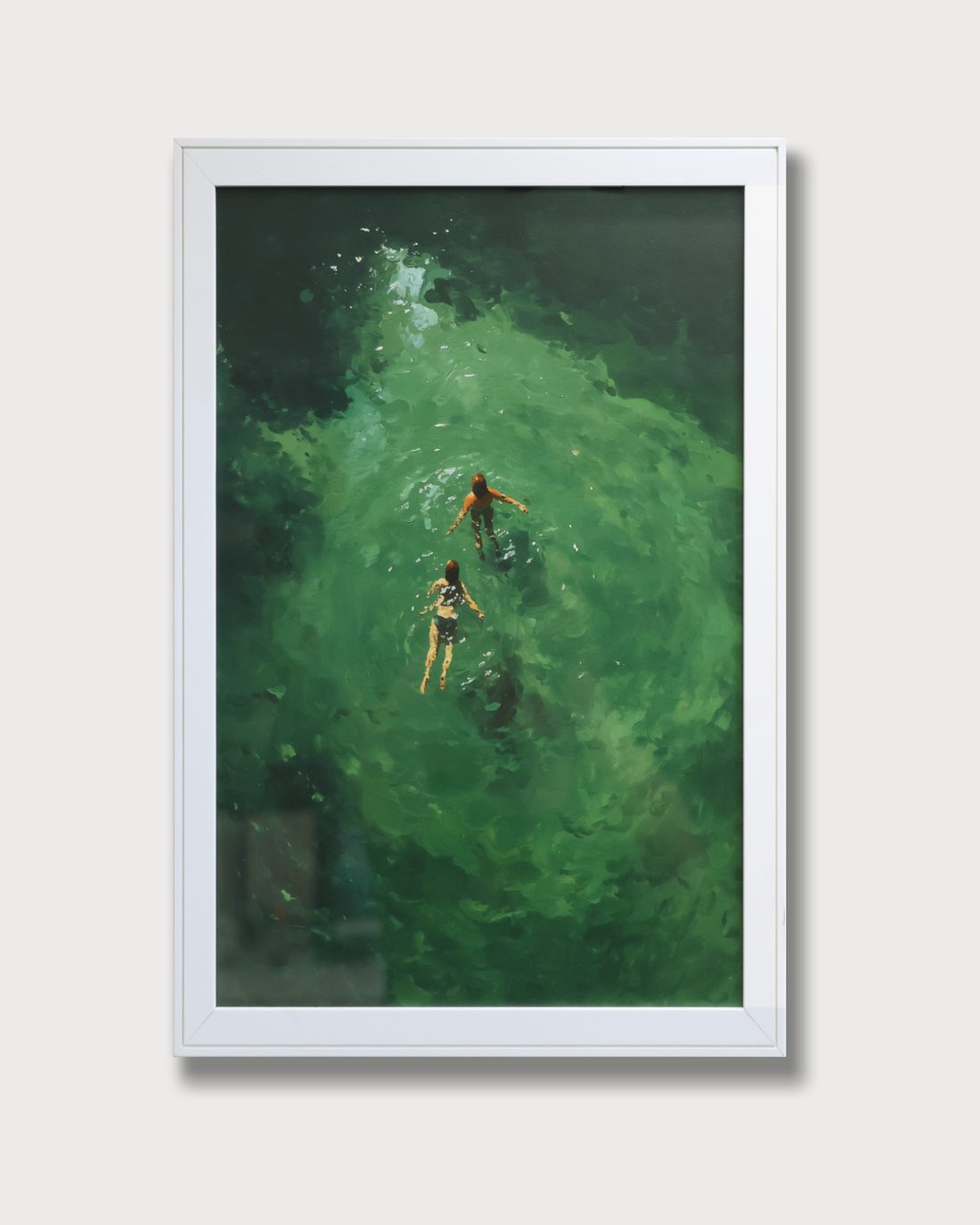 A green painting framed right to the edge in a white frame, behind glass