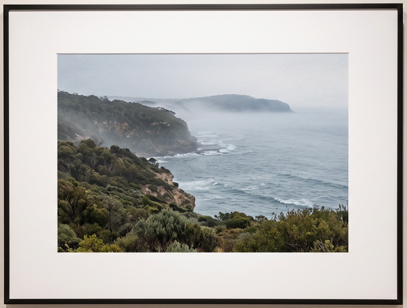 A coastal photograph printed and framed in black with a white mat